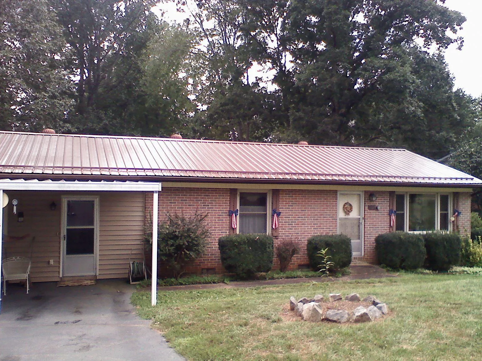 Bronze metal roof and carport on a brick ranch home — Roof Repair work by our crew in Willow City