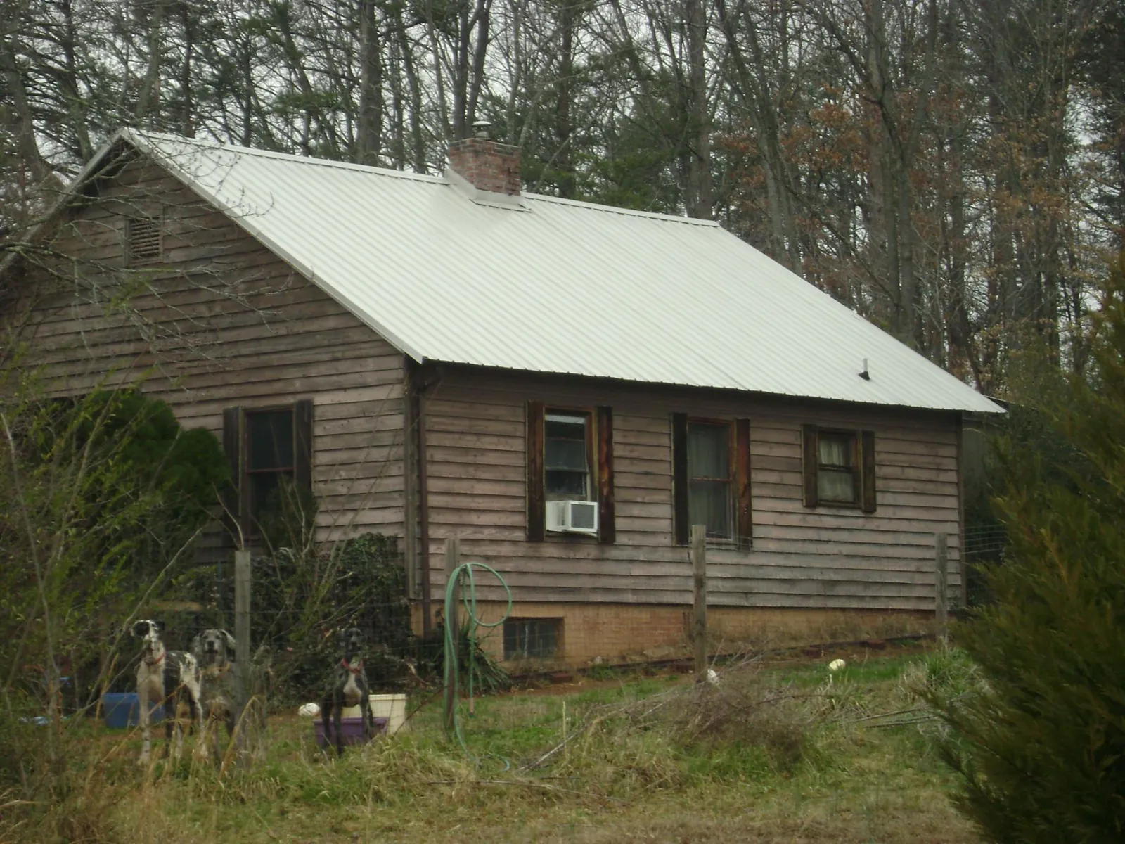 White metal roof on an old wood sided farmhouse, from a Metal Roof Installation job in Willow City